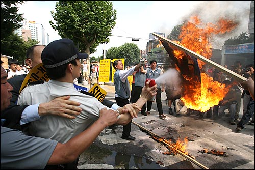 행진 시작을 앞두고 기습적으로 이뤄진 인공기 화형식에 대해 경찰이 소화기를 뿌리며 불을 끄려하자, 일부 참가자들이 경찰을 붙잡으며 제압하고 있다. 